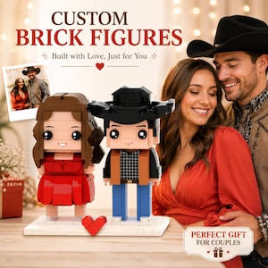 Pode incluir: Duas figuras de blocos personalizadas sobre uma base branca com um pequeno coração vermelho. Uma figura tem cabelos castanhos longos e um vestido vermelho, enquanto a outra usa um chapéu de cowboy preto, camisa xadrez, colete castanho e calças azuis.