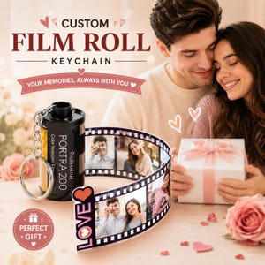 May include: A black film roll keychain featuring a retractable strip of printed photographs. The canister is labelled Portra 200. The extended film strip displays multiple images of a couple and ends with a graphic that says LOVE with a heart icon.