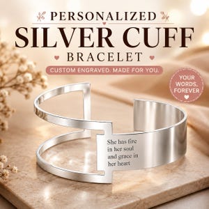 Può includere: Un bracciale a polsino in argento con la scritta "She has fire in her soul and grace in her heart" incisa. Il bracciale è personalizzato e inciso su misura. Le parole "Bracciale a Polsino in Argento Personalizzato" sono in alto.