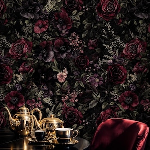 May include: A dark, floral wallpaper featuring deep red roses and other flowers. A gold tea set with two cups and saucers sits on a table, with a red velvet chair in the foreground. The overall theme is elegant and vintage.