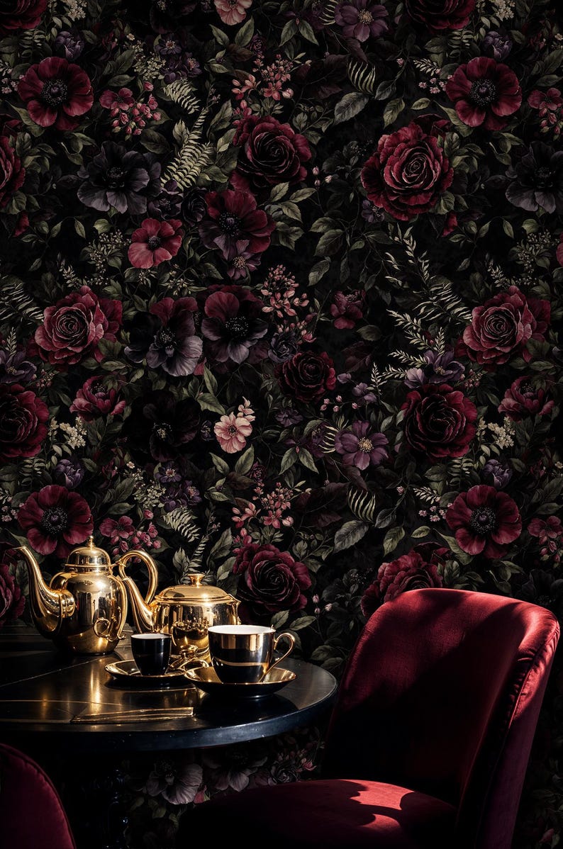 May include: A dark, floral wallpaper featuring deep red roses and other flowers. A gold tea set with two cups and saucers sits on a table, with a red velvet chair in the foreground. The overall theme is elegant and vintage.