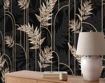 Puede incluir: Papel tapiz negro y dorado con un patrón geométrico de arcos y líneas verticales. El patrón está superpuesto con un diseño de hojas de helecho. El papel tapiz se muestra en una habitación con una mesa de madera y una lámpara.