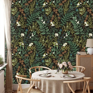Puede incluir: Una mesa de comedor con un mantel blanco y un papel tapiz con estampado floral. El papel tapiz presenta un fondo oscuro con dise&ntilde;os florales verdes y blancos. Hay dos sillas a cada lado de la mesa y un jarr&oacute;n de flores en el centro.