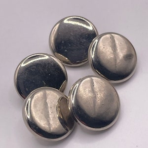 May include: Four silver-toned round buttons with a smooth, shiny finish.