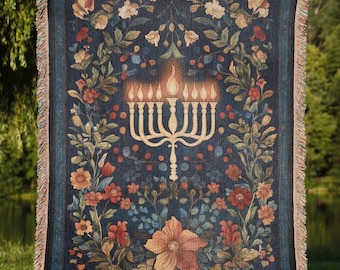 May include: A woven tapestry throw blanket with a floral pattern and a menorah design in the center. The menorah is gold and the flowers are red, pink, and white.
