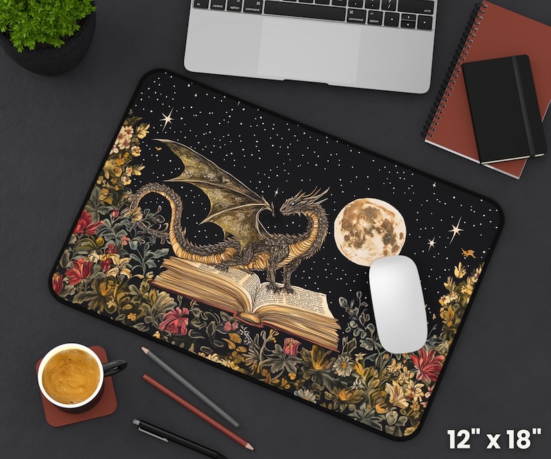 May include: A black and gold dragon with wings outstretched sits on top of an open book. The dragon is surrounded by flowers and stars on a black background. The book is open to a page with text. The mousepad is 30.5 cm by 45.7 cm.