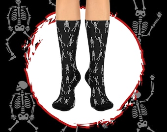 May include: A pair of black socks with a white skeleton pattern. The skeletons are dancing and have a fun, whimsical look.