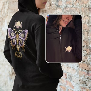 Puede incluir: Sudadera negra con cremallera, con un diseño de mariposa púrpura y dorada en la espalda y un diseño de triple luna en la parte delantera.