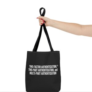 Puede incluir: Bolsa de tela negra con texto blanco que dice "TWO-FACTOR AUTHENTICATION, TWO-PART AUTHENTICATION, and MULTI-PART AUTHENTICATION".
