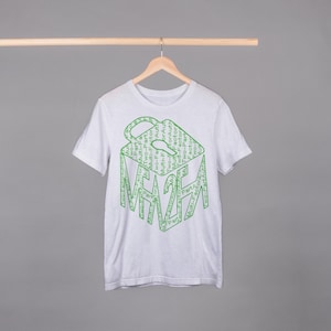 Puede incluir: Una camiseta blanca con un gráfico verde de un candado con la palabra "MAZE" escrita en su interior. El candado está formado por las palabras "Autenticación de dos factores" repetidas muchas veces.