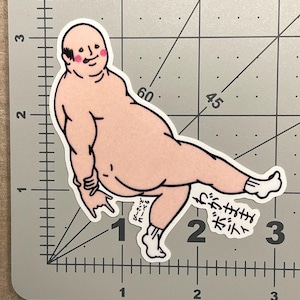 May include: A sticker featuring a cartoon illustration of a nude, bald figure with rosy cheeks, wearing white socks. The figure is in a dynamic pose with one leg extended. Japanese text is included.