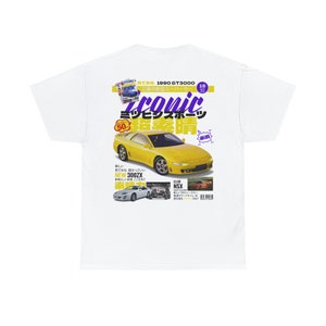 Peut inclure: Un t-shirt blanc avec un graphique de voiture jaune et du texte japonais qui se lit "Iconic Mitsubishi Evolution". Le texte est en police violette et jaune. La voiture est une Mitsubishi Evolution jaune avec un intérieur noir. Le texte "New 300ZX" est également visible sur le t-shirt.