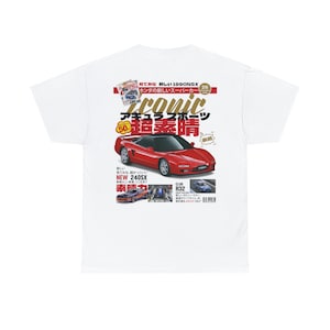 May include: A white t-shirt with a red and black magazine print featuring a red Honda NSX sports car. The magazine cover reads "Iconic" and "超蓋睛" in Japanese. The magazine also features a blue car and the text "NEW 240SX" and "CLUB R32".