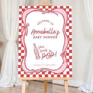 She’s Ready to Pop Baby Shower Welcome Sign – 50s Soda Pop-Inspired Canva Template. This Baby Shower Sign Template is a charming and playful way to welcome guests to a bubbly baby bash. Designed in a retro 1950s soda pop shop style, it features whimsical hand-drawn details of a bottle of Cola, glass of pop & a dirty soda, with a wavy pink & red border tied with bows on a red & white chequered background. Retro vintage style whimsical fonts are also used. Gender-neutral baby shower. 18x24, 20x30