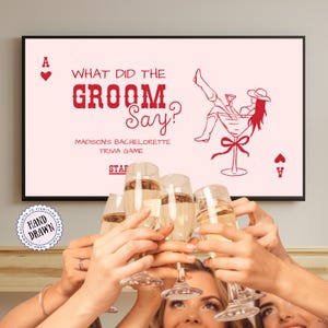 Puede incluir: Un letrero enmarcado de juego de trivia para despedida de soltera rosa con el texto rojo "WHAT DID THE GROOM Say?". El letrero incluye una ilustración de cóctel y símbolos de naipes. Se levantan copas de champán para brindar.