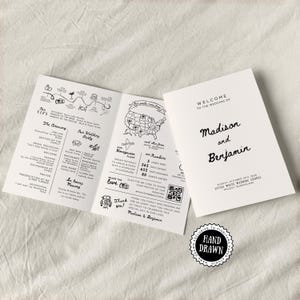 May include: A white wedding program with black handwritten text. The program includes the names "Madison and Benjamin" and details about the ceremony, wedding party, and honeymoon. A "Hand Drawn" sticker is visible.