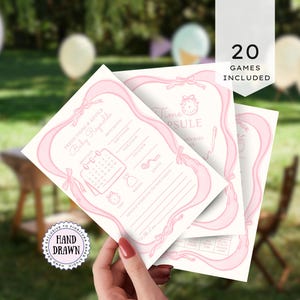 Può includere: Tre biglietti di previsioni e consigli per baby shower con nastri e fiocchi rosa. I biglietti includono richieste per la data di nascita, il peso e altri dettagli del bambino. Le parole "Time Capsule" e "20 Games Included" sono visibili.