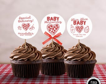 May include: Three chocolate cupcakes with brown frosting and decorative toppers. The toppers have red text and graphics, including the phrases "Special Delivery!", "Baby Hernandez", and "Slice, Slice Baby". The cupcakes sit on a red and white checkered tablecloth.