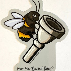 May include: A sticker featuring a cartoon bee holding a silver trumpet. The bee is black and yellow with white wings. The text "Have You Buzzed Today?" is at the bottom. The website www.mountainpeakmusic.com is printed on the trumpet.