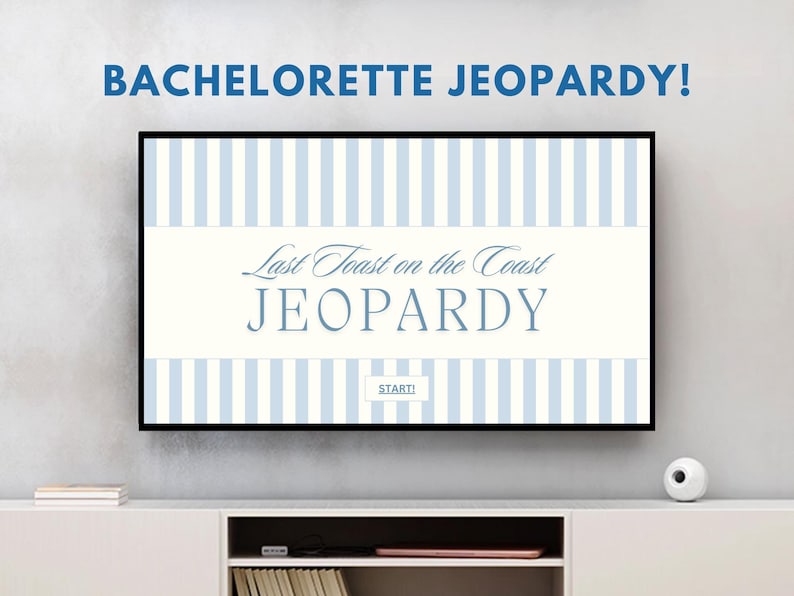 May include: A television screen displaying a blue and white striped background with the text "Last Toast on the Coast JEOPARDY" and the word "START" in a white box. The screen is on a white entertainment center with a white speaker on the right side.