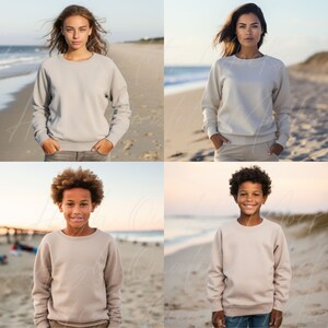 May include: Four people wearing beige crewneck sweatshirts, standing on a beach. The people are smiling and looking at the camera.