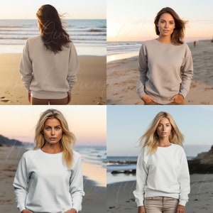 May include: Four women wearing different colored sweatshirts on a beach. The sweatshirts are all the same style, with a crew neck and long sleeves.