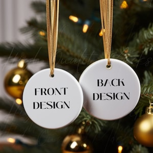 Puede incluir: Dos adornos navideños de cerámica blanca con una cuerda dorada colgando de un árbol de Navidad. El adorno delantero dice "FRONT DESIGN" y el adorno trasero dice "BACK DESIGN".