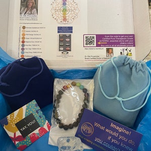 May include: A blue box with a variety of items inside, including a chakra bracelet, a small bag, a crystal, and a card that says "Imagine! What would you do, if you knew, you couldn't fail?" The box also includes a card with the text "A Drop In The Wellspring" and a diagram of the seven chakras.