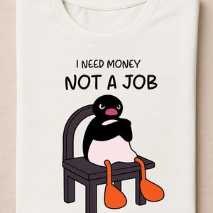 Può includere: T-shirt bianca con la scritta "I NEED MONEY NOT A JOB". La maglietta presenta un pinguino dei cartoni animati seduto su una sedia, con piedi arancioni e un corpo bianco e nero.
