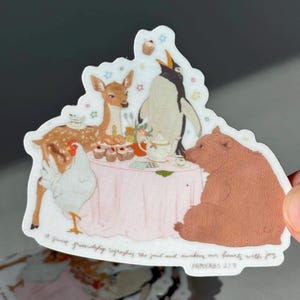 Puede incluir: Una pegatina caprichosa que representa una escena de fiesta de té con un ciervo, un pingüino, un oso y una gallina alrededor de una mesa rosa. La pegatina incluye el texto "a sweet friendship refreshes the soul and awakens our hearts with joy" y "PROVERBS 27:9".