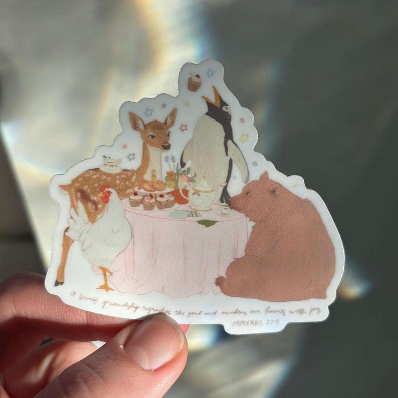 May include: A sticker featuring a whimsical tea party scene. A deer, penguin, bear, and chicken are gathered around a pink table with cupcakes and a teapot. The text reads, "A sweet friendship refreshes the soul and makes our hearts with joy." Proverbs 27:9.
