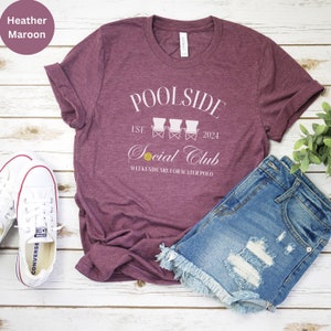 Pode incluir: Camiseta heather marrom com texto branco que diz "Poolside Est. 2024 Social Club Weekends are for Water Polo". O texto &eacute; cercado por tr&ecirc;s cadeiras de praia brancas.