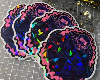 May include: Three iridescent stickers featuring a dark figure with a menacing expression. The figure is surrounded by a pink, holographic background with a jagged, wavy border.