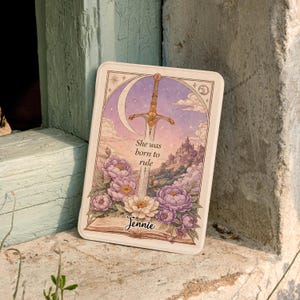 May include: A rectangular, off-white decorative tray with a fantasy-themed illustration. The artwork features a sword, moon, castle, and flowers in shades of purple, pink, and gold. Text on the tray reads "She was born to rule" and "Jennie".
