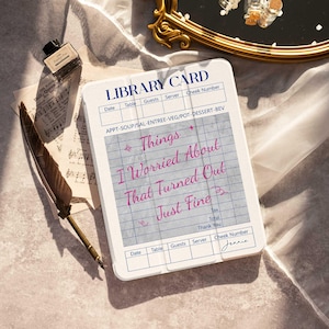 May include: A white library card-style notepad with the text "Things I Worried About That Turned Out Just Fine" in pink script. The notepad has a blue grid pattern and the word "Jennie" written at the bottom. A quill pen, ink bottle, and sheet music are also visible.
