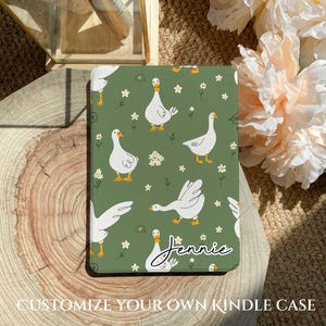 May include: A green Kindle cover featuring a white goose pattern and the name "Jennie" printed at the bottom.