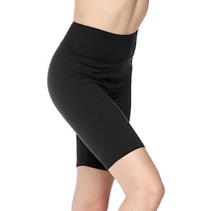 May include: Black high-waisted biker shorts. The shorts are made of a stretchy material and have a fitted design. The shorts are knee-length and suitable for athletic activities or casual wear.