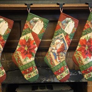 Peut inclure: Quatre bas de Noël aux motifs festifs. Chaque bas présente une illustration du Père Noël, un poinsettia rouge et une étiquette. Les bas sont rouges, verts et crème, avec un motif à carreaux et floral.