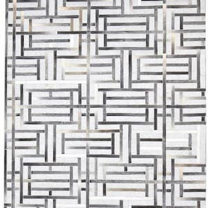 Könnte beinhalten: Ein rechteckiger Teppich mit einem geometrischen Muster aus zusammengenähten Streifen in Weiß-, Grau- und Schwarztönen. Das Design besteht aus ineinandergreifenden horizontalen und vertikalen rechteckigen Formen, die einen gitterartigen Effekt erzeugen.