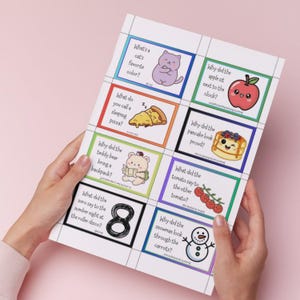 K&ouml;nnte beinhalten: Ein Blatt Papier mit farbenfrohen illustrierten Karten mit R&auml;tseln und niedlichen Cartoon-Bildern. Die Karten enthalten Fragen wie "Was ist die Lieblingsfarbe einer Katze?" und "Warum hat der Teddyb&auml;r einen Rucksack mitgebracht?"