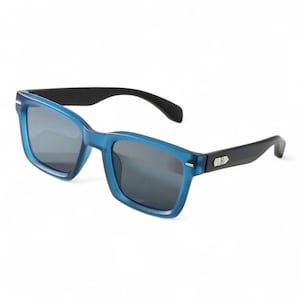 May include: Blue sunglasses with black arms. The sunglasses have a square frame and dark lenses. The arms have a silver accent near the hinges. The sunglasses are set against a white background.