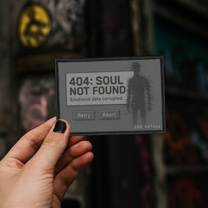May include: A rectangular patch with the text "404: SOUL NOT FOUND" and "Emotional data corrupted." A silhouette of a person is on the right. The patch has "Retry" and "Abort" buttons.