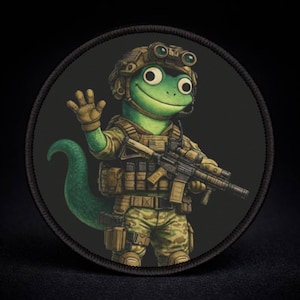 May include: Round patch featuring a green lizard character in military gear, including a helmet, vest, and camouflage uniform. The lizard is holding a rifle and waving. The patch has a black border and background.