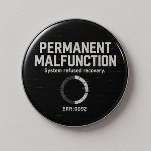 Może przedstawiać: Okrągły czarny przypinany guzik z białym napisem PERMANENT MALFUNCTION oraz System refused recovery. Pod tekstem znajduje się biała okrągła ikona ładowania oraz kod alfanumeryczny ERR:0092 wyśrodkowany na czarnej powierzchni przedmiotu.