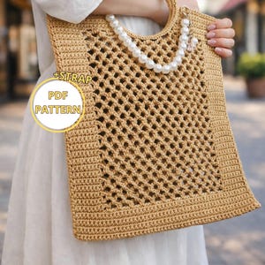May include: A light brown crocheted tote bag with a square shape and a lattice design. It has a pearl beaded strap and a circular handle. The text "+STRAP PDF PATTERN" is visible on the bag.