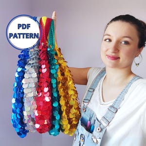 Puede incluir: Una colección de tiras de tela de lentejuelas de colores en azul, plateado, rojo, verde azulado y dorado. Las tiras se sostienen, mostrando su textura brillante. Un gráfico circular con el texto "PDF PATTERN" es visible.