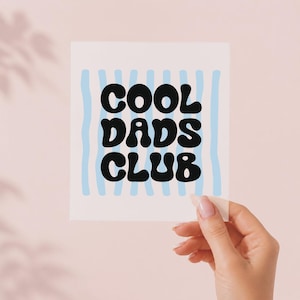 Può includere: Un cartoncino quadrato bianco con il testo nero COOL DADS CLUB in un carattere grassetto, arrotondato e ondulato. Lo sfondo del testo è composto da strisce verticali azzurre che corrono dal bordo superiore a quello inferiore del design.