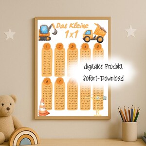 May include: A framed multiplication table print with construction vehicles and the text "Das Kleine 1x1". The print features a series of multiplication tables in a vertical format, with numbers and equations in a brown font.