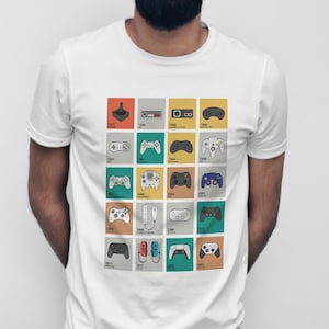May include: White t-shirt with a grid of colourful squares, each showing a different video game controller from 1977 to 2022. The controllers are in various colours and designs, representing the evolution of gaming technology.
