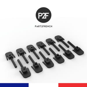 May include: A collection of black plastic clips, arranged in rows, against a white background. The clips have a unique design with a rectangular base and a central post. The logo "P2F" and the text "PART2FRENCH" are in the top center.